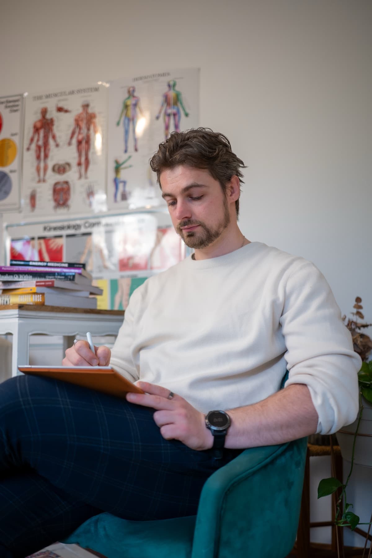 Vildan seated in the clinic, taking notes on a clipboard