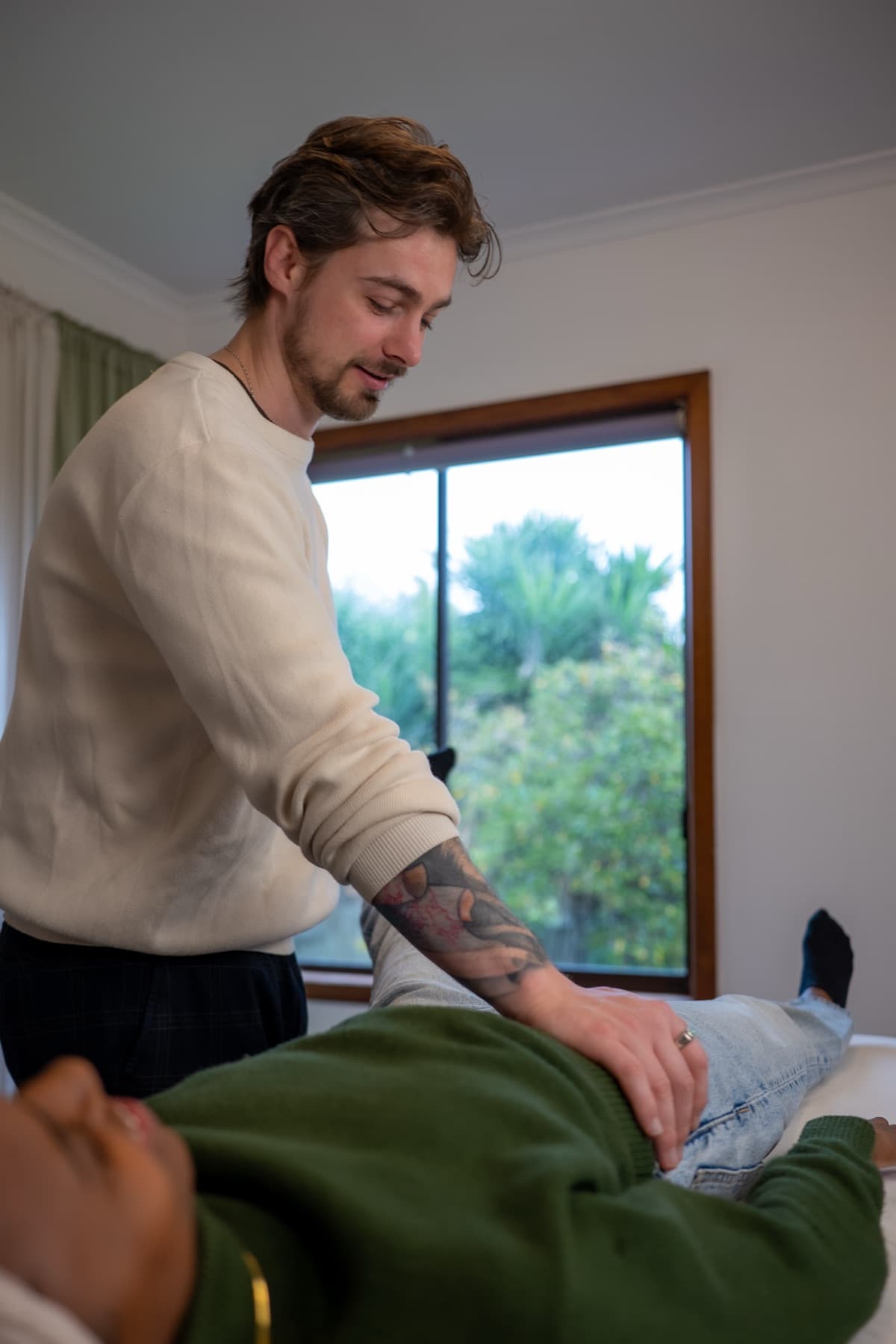 Vildan holding a client’s leg on the treatment table, testing the muscle